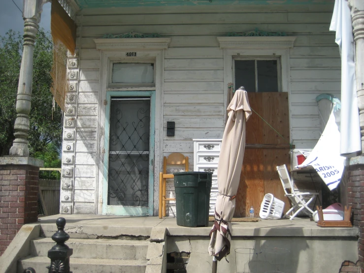 a small porch with chairs and an umbrella