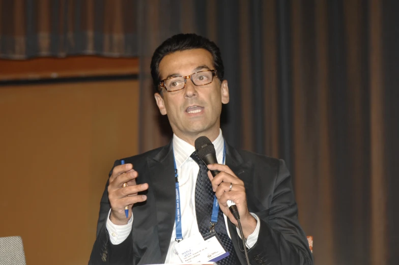 a man talking on a microphone at a conference