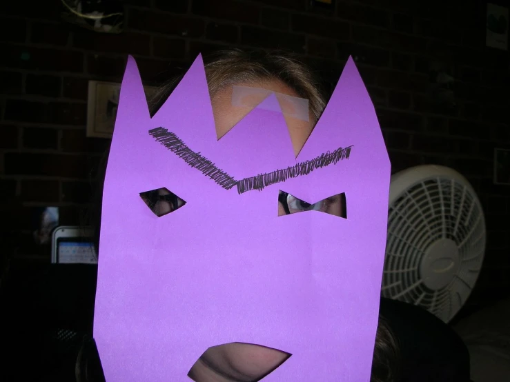 a young child in a purple batman mask