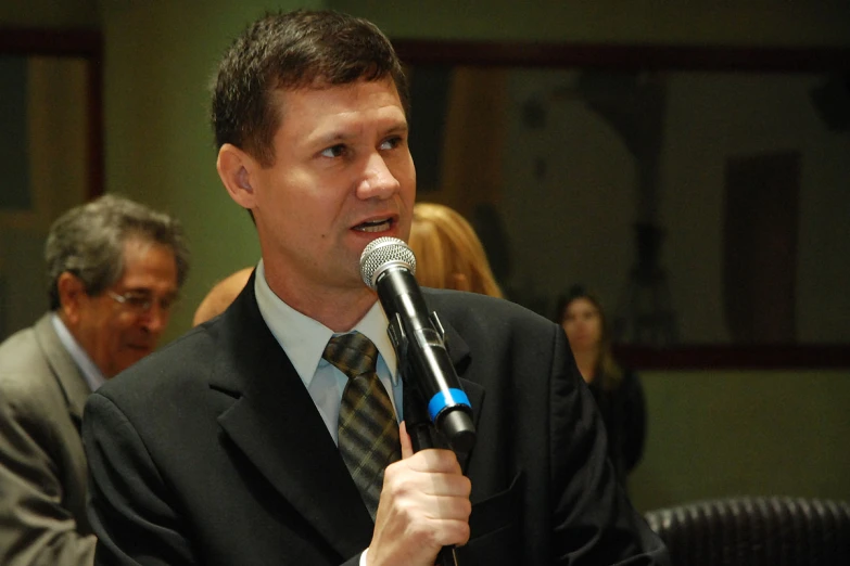 a man holding a microphone wearing a suit