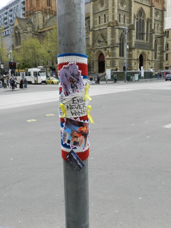 stickers on a traffic pole at the intersection of a street