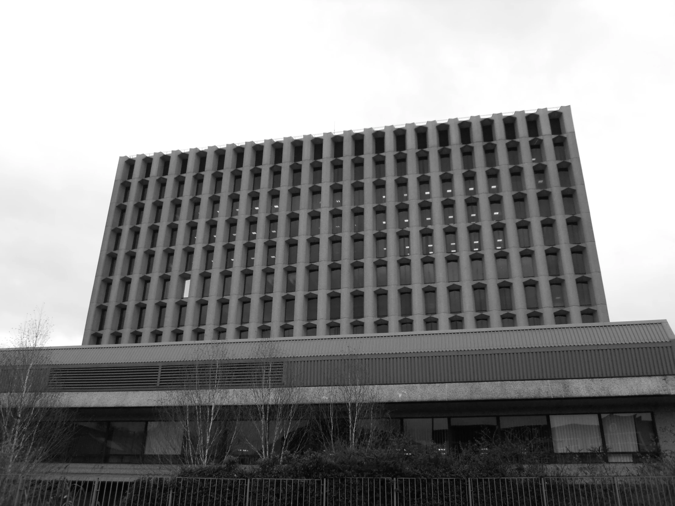 black and white po of a building with a fence around it