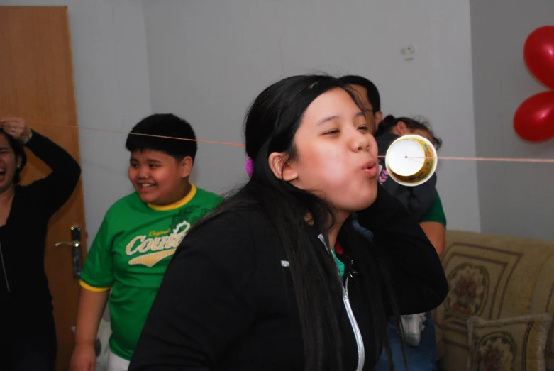 a woman singing on the karaoke surrounded by her friends