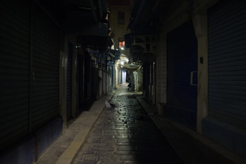 an empty street in an alley with dark lighting