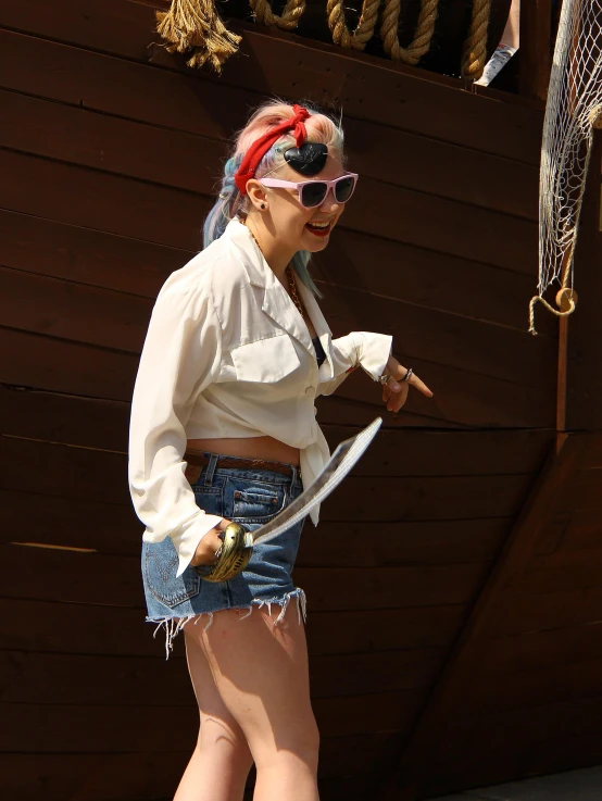 a woman in short shorts standing outside next to a wood wall