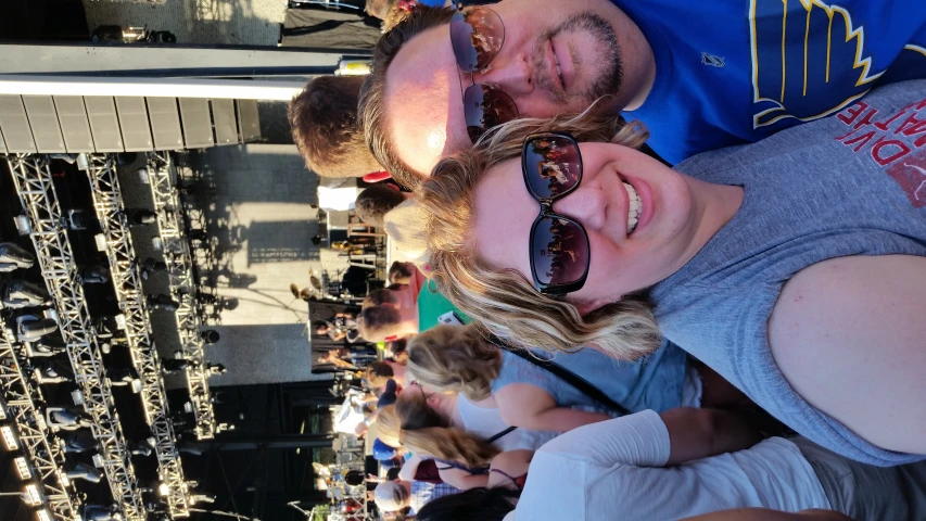 a couple takes a picture on stage as the crowd waits