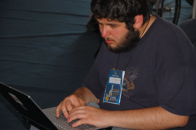 a man sitting at a table on a laptop computer