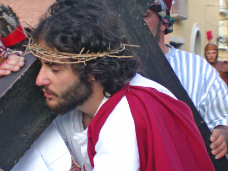 a man wearing a crown with his hand over his head