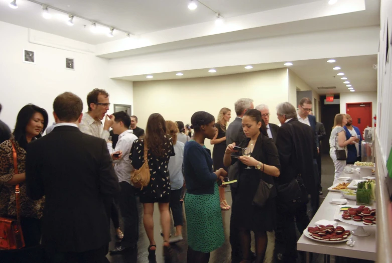 a group of people standing around a long table