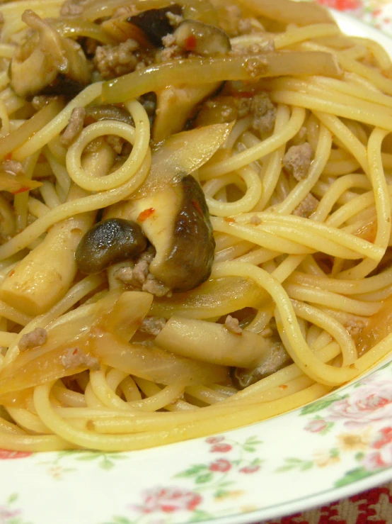 a pasta dish with noodles and mushrooms sitting on a table