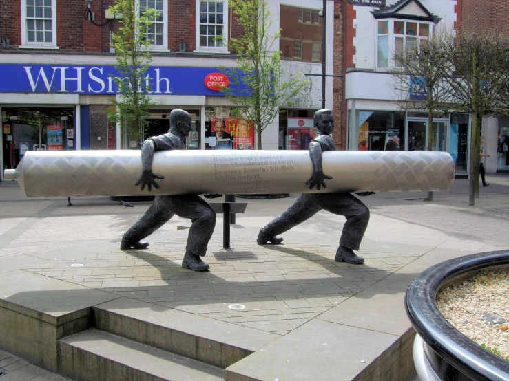 two people carrying an oversized object on top of them