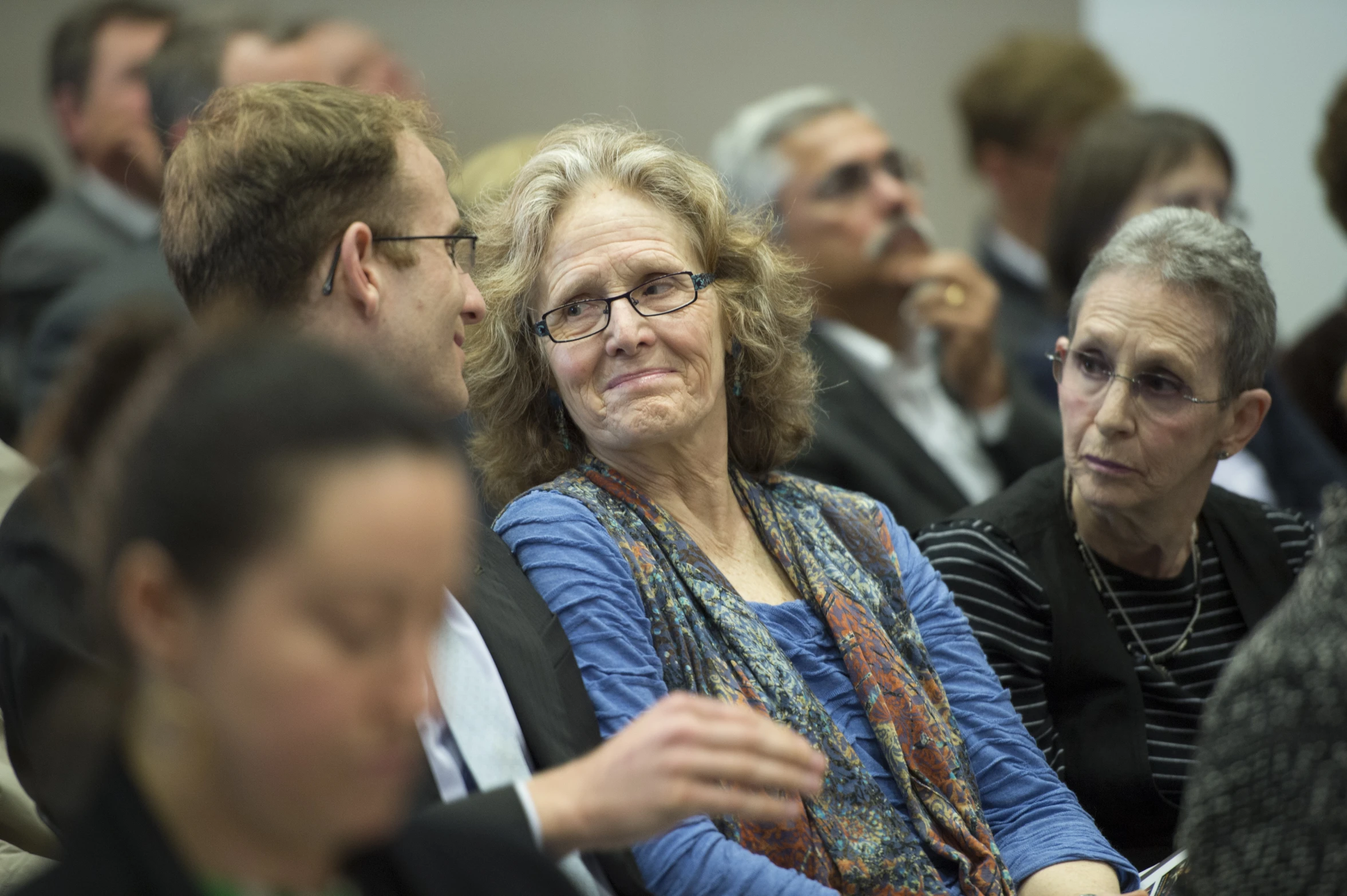 people sitting in a group listening to someone at the event