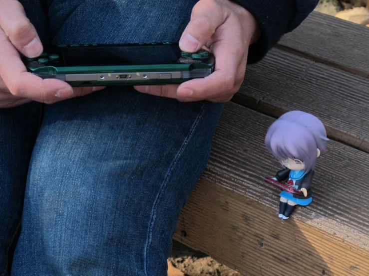 the doll is holding the phone while it sits on a bench