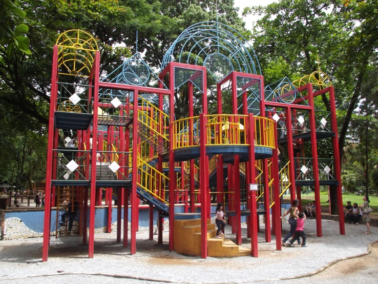 a playground with many children and adult playing equipment