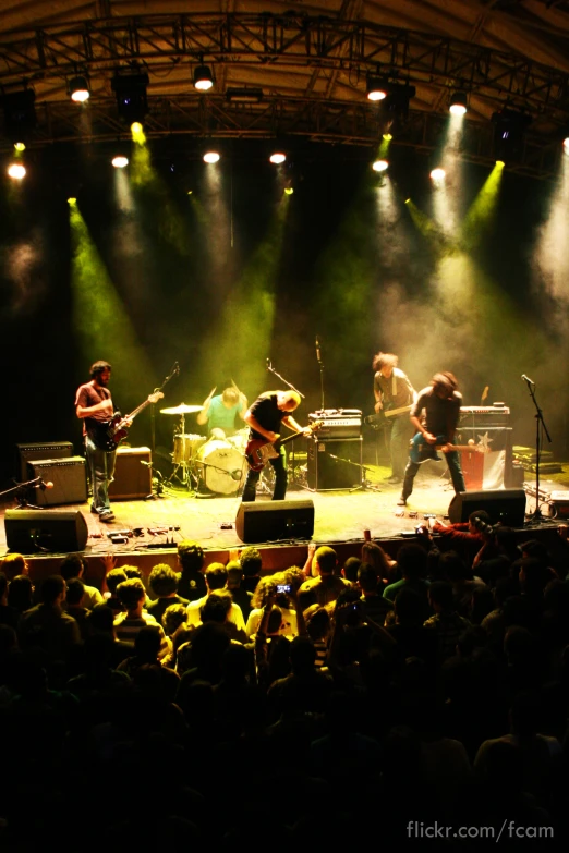 two people are playing guitars on stage during a concert