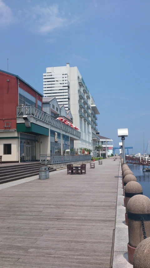 a view down the sidewalk of a building and boats