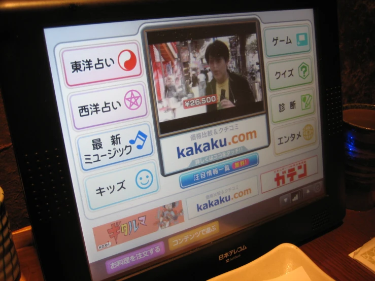 a television screen showing a man on the show kakaku com