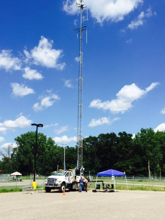 two men at the base with a tall antenna