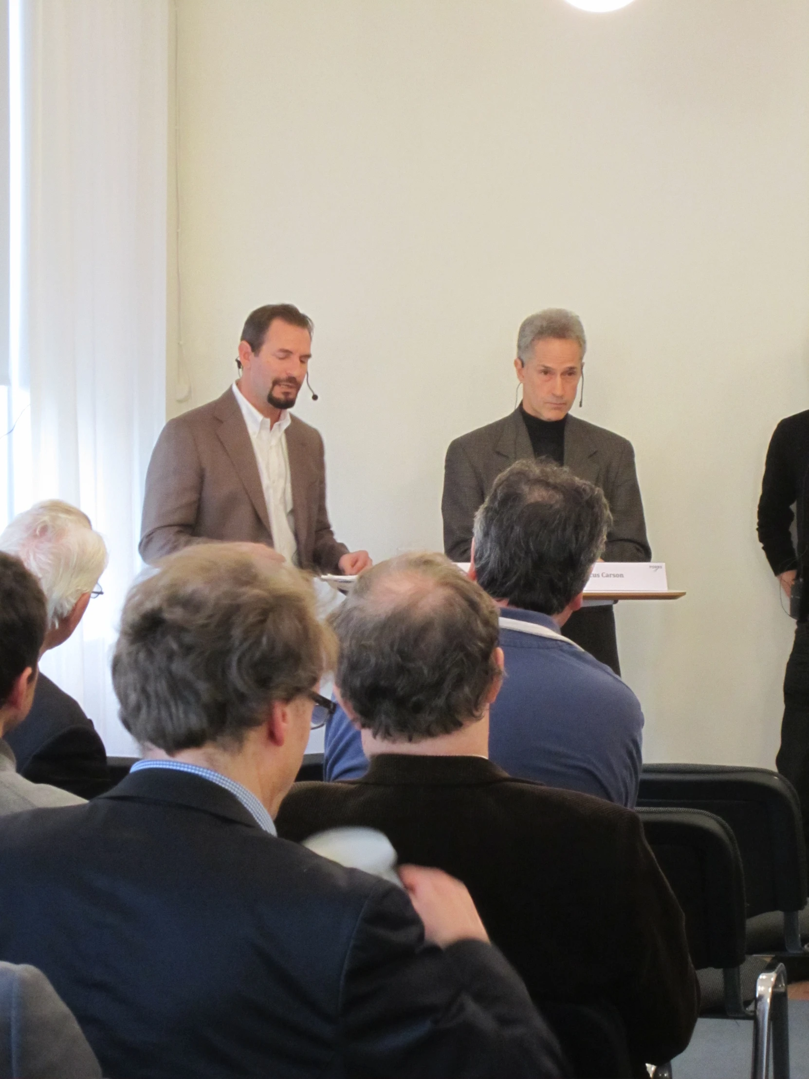 four men standing in front of each other in a room