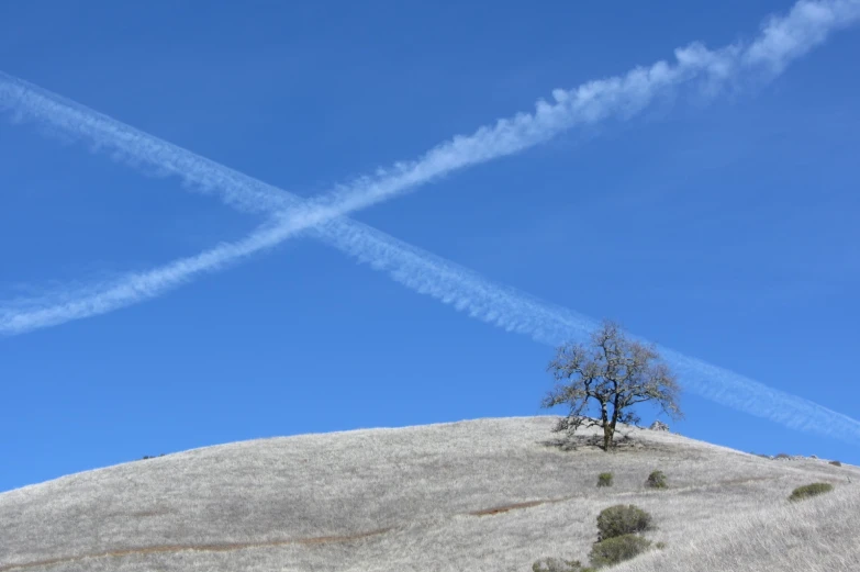 an airplane flying over the top of a hill