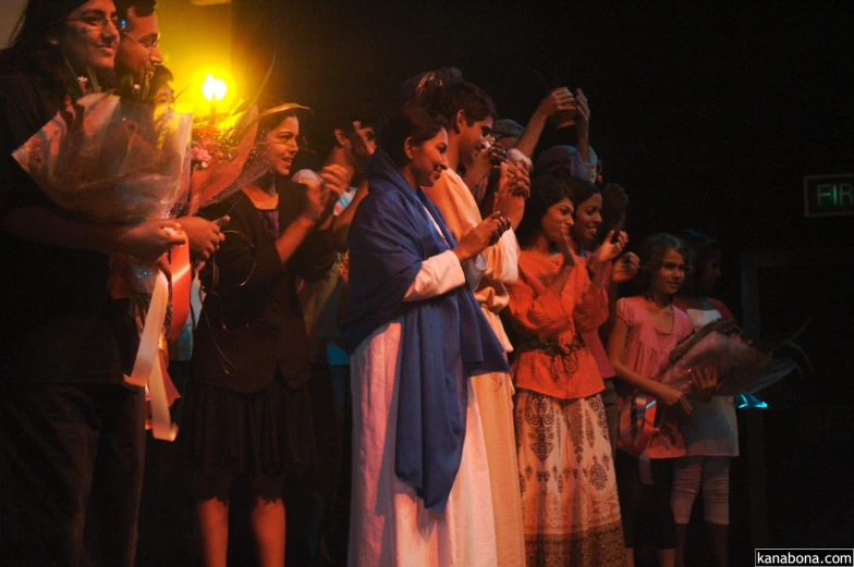 woman dressed in white dress singing into a microphone