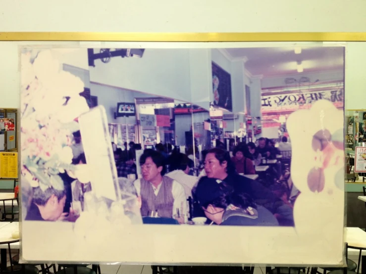 an old picture of men sitting around a cafe