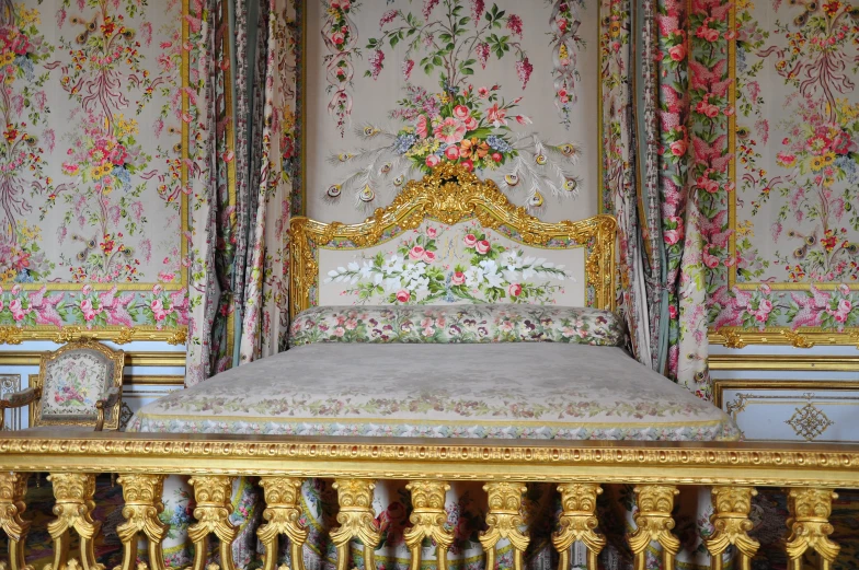 the bed is decorated in gold and pink flowers