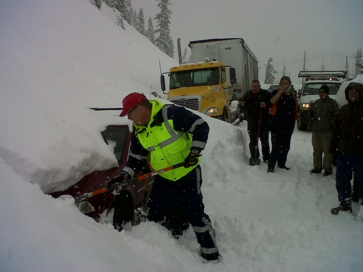 a man shoveling the snow off a truck