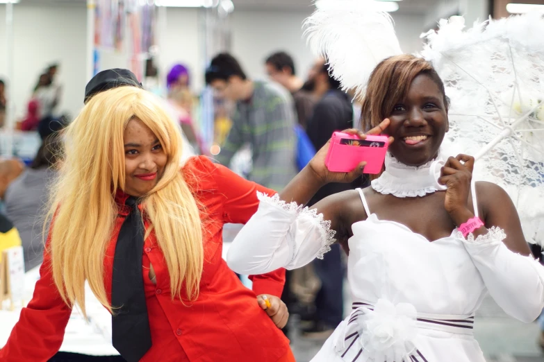 two women in fancy dresses stand and laugh