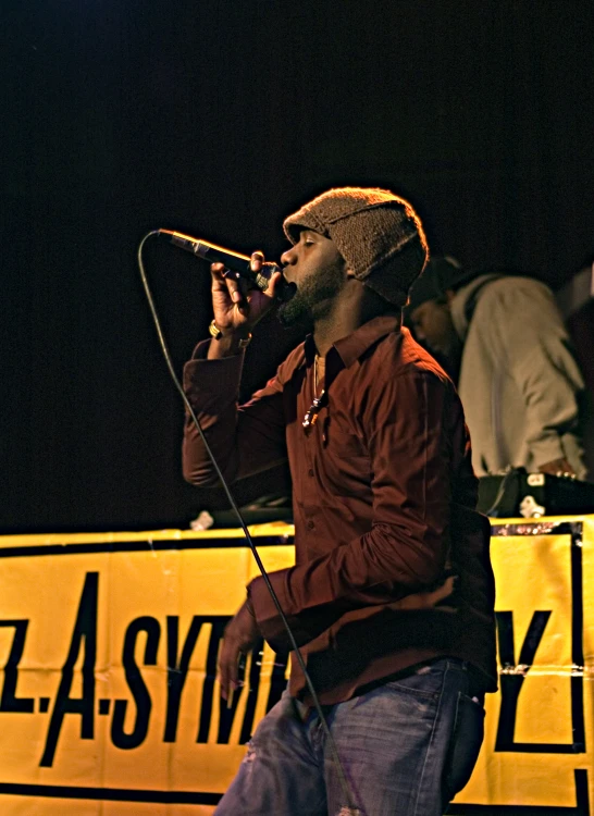 man on stage singing into a microphone