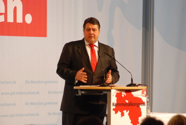 a man stands in front of a podium at a public event