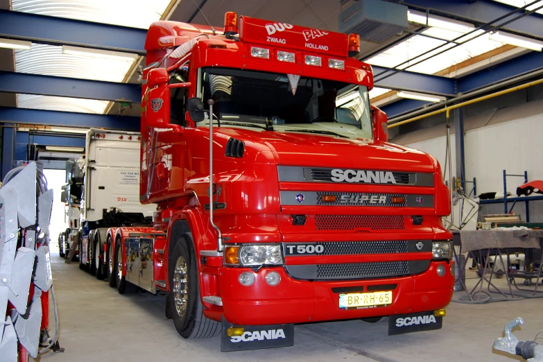 a large red truck is parked inside of a building