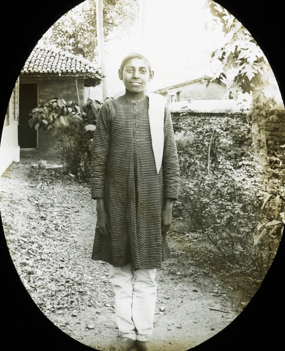 a man in traditional black clothing standing in an old picture