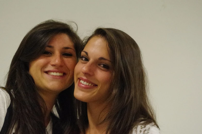 two young women posing for the camera with one of them smiling