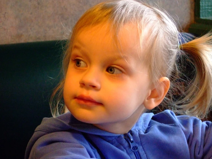 a child is holding a piece of broccoli in her hand