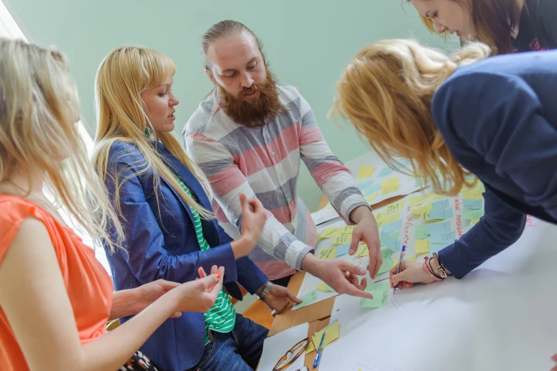 a group of people gathered around a table with craft paper