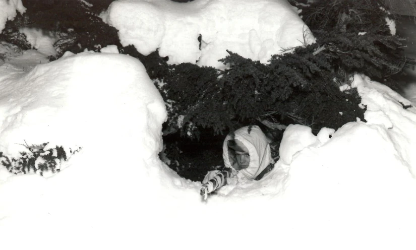 a man walking in deep snow near trees