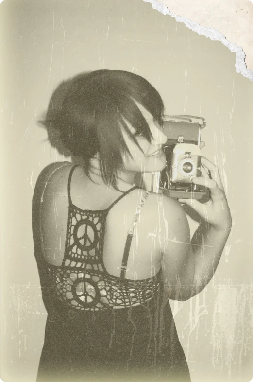 a woman taking a pograph of herself with a polaroid camera