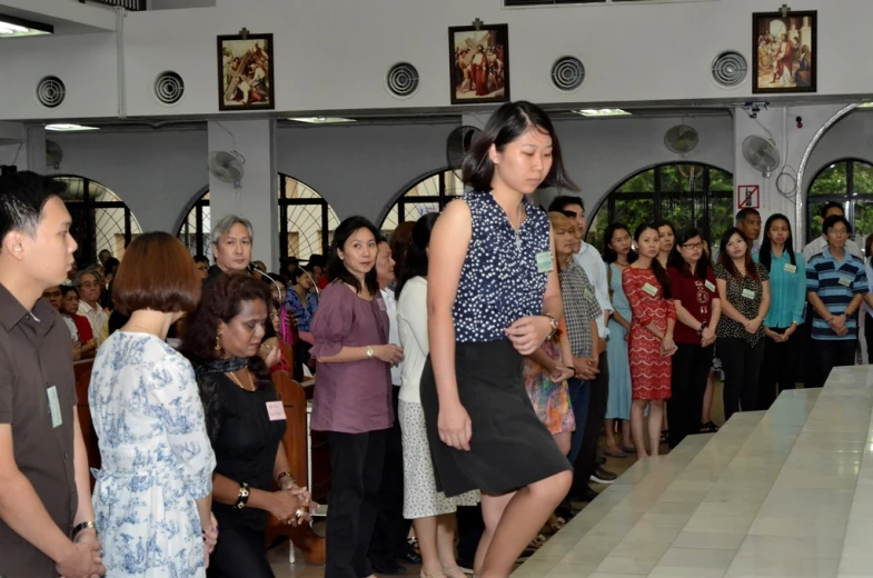 many people gathered to watch a woman walk down the catwalk