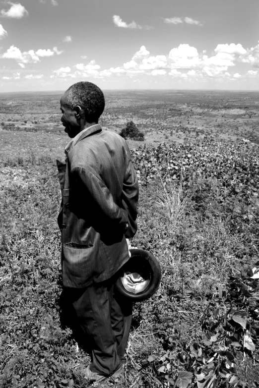 a man stands alone in a large grassy plain