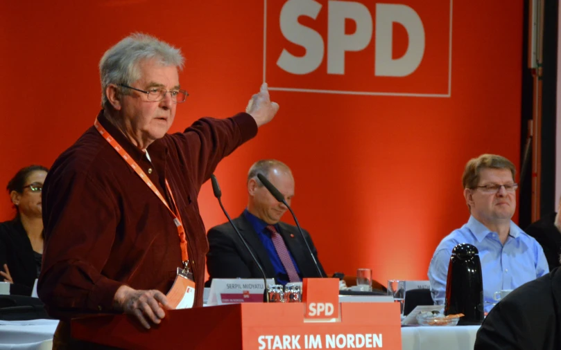 a man pointing to a sign that reads spd