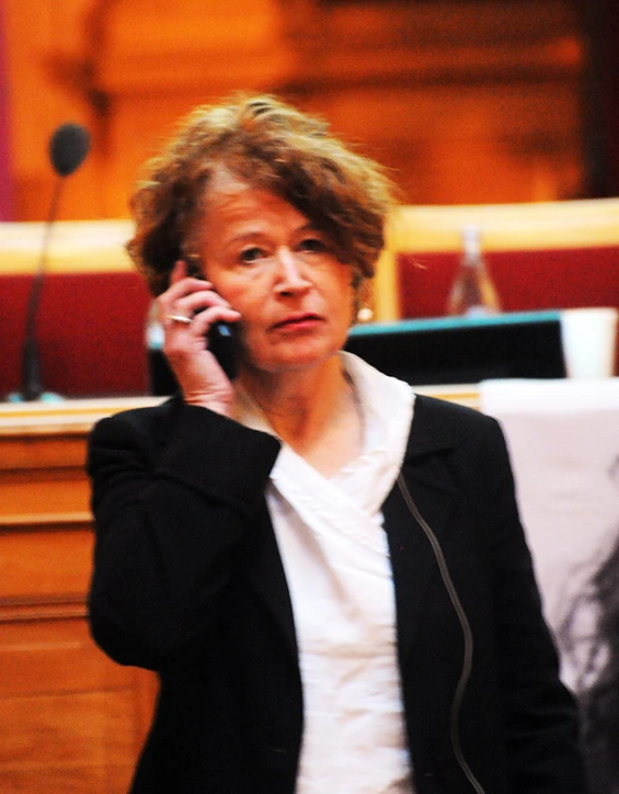 a woman talking on her cell phone in front of a table