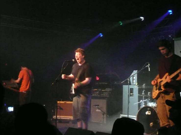 two men on stage performing while people watch