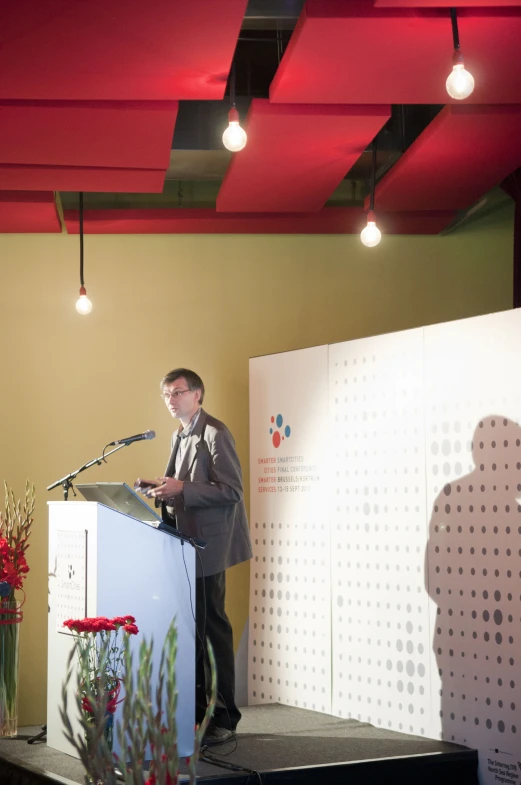 a man standing at a podium speaking at an event