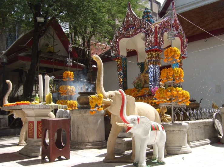 elephants are standing outside next to a statue