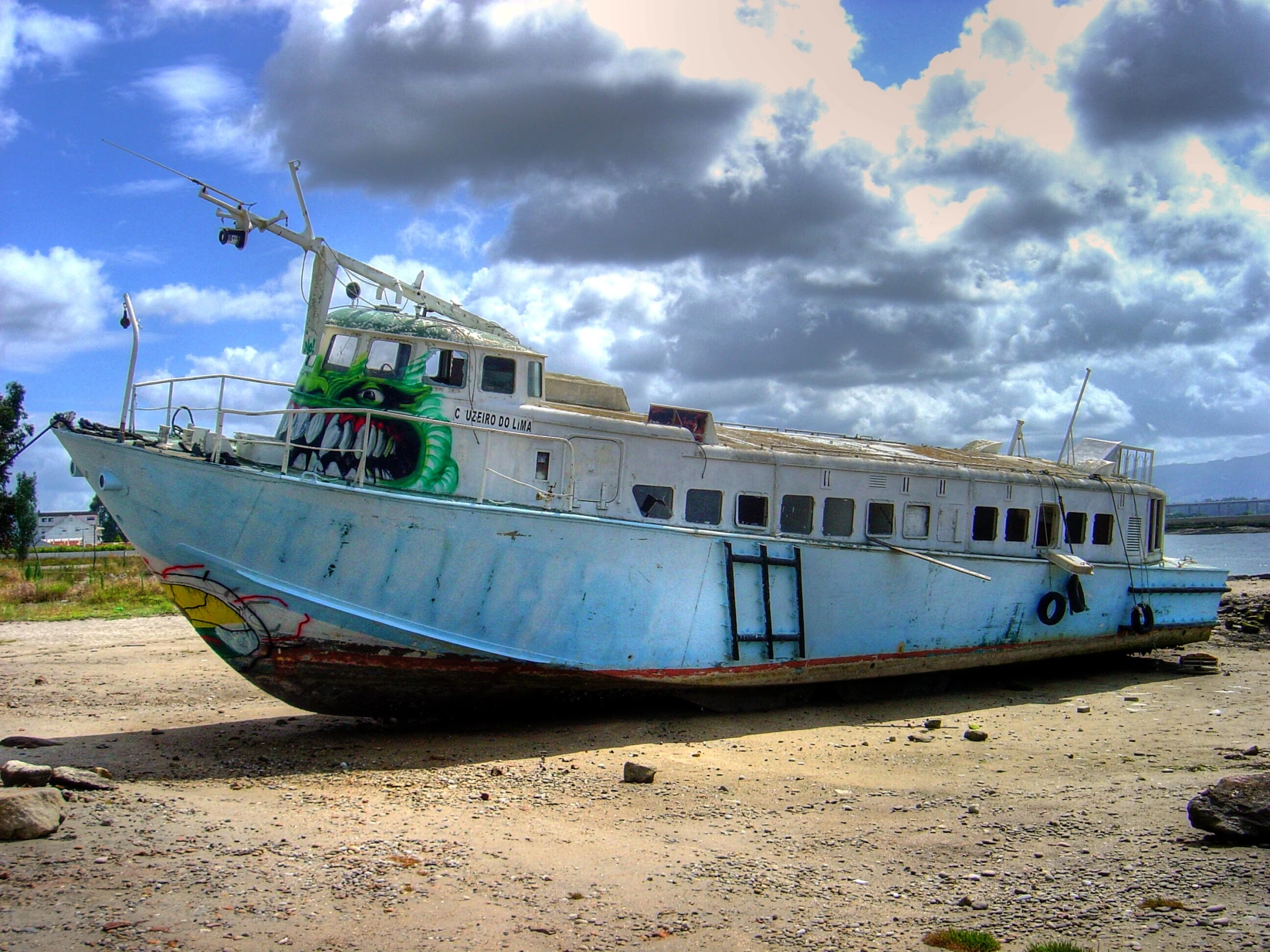 a very large blue boat in the middle of the beach