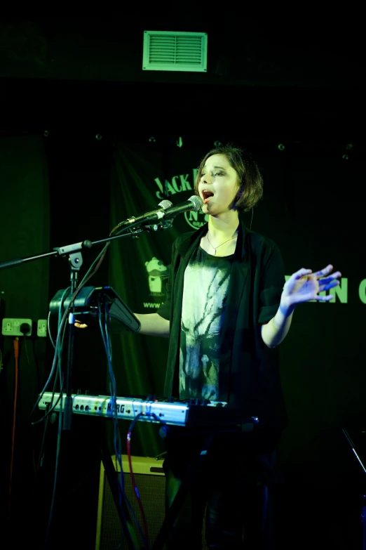 a person playing keyboard with microphone on stage