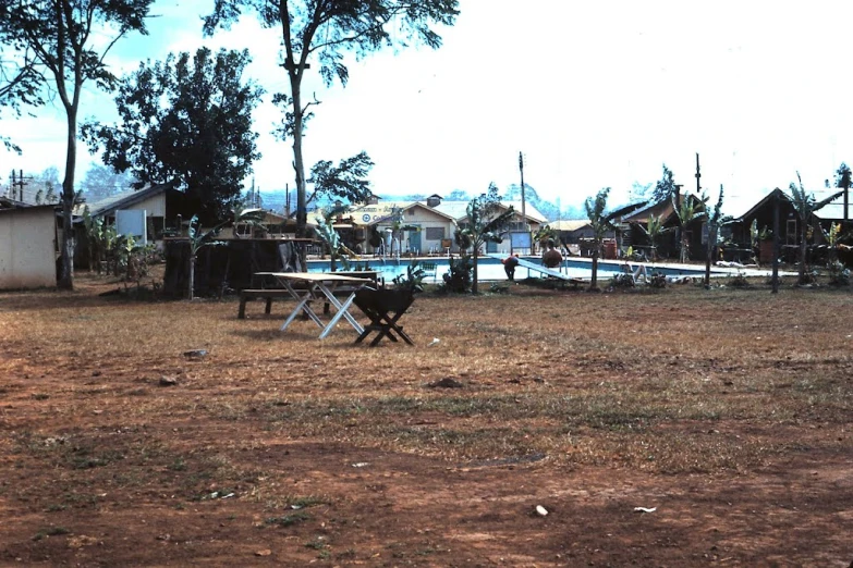 the dog is sitting on the picnic table in the yard