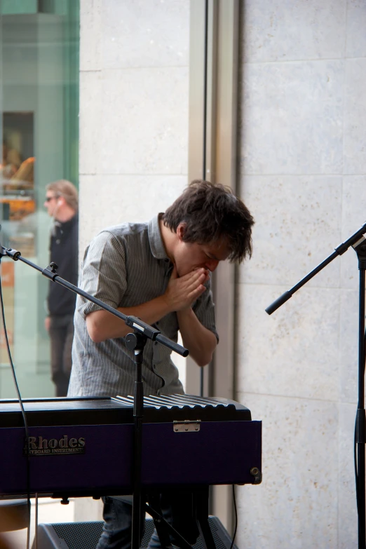 the man is sitting at a microphone in front of a microphone