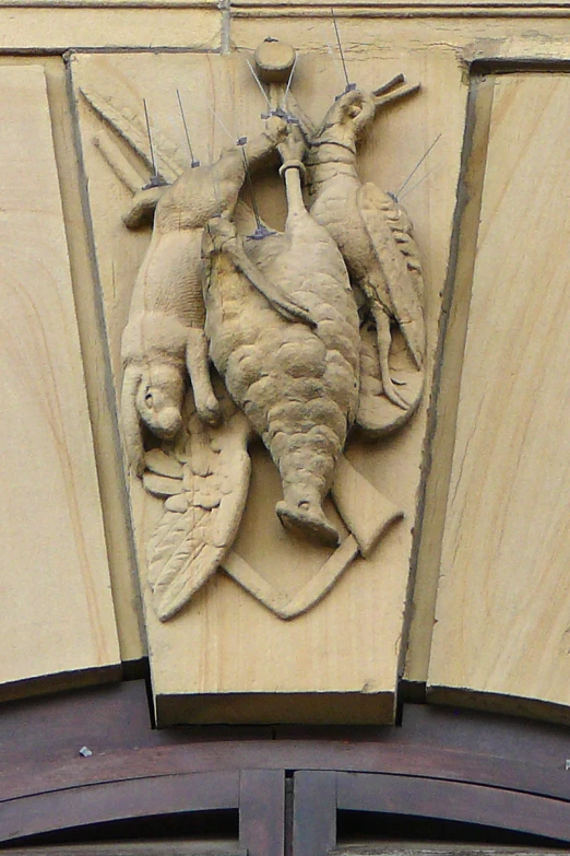 an elaborate carving is above a doorway with a clock on the wall